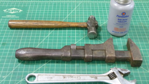 Anti-seize compound jar with wrenches on a workbench